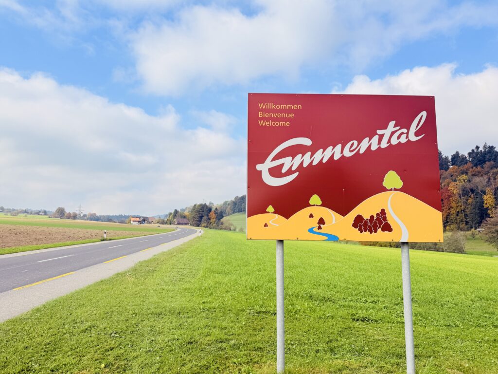 Emmental Willkommensschild vor grünen Hügeln und blauem Himmel