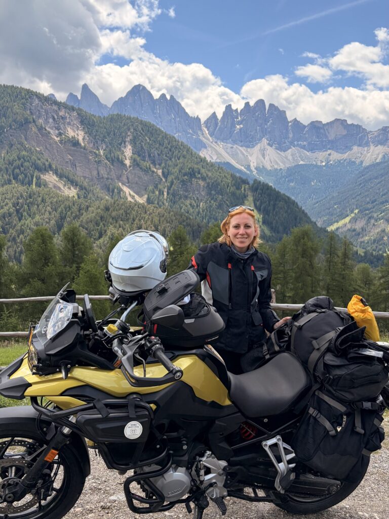 Motorradfahrerin auf einer Passstrasse in den Dolomiten mit Blick auf die Berggipfel