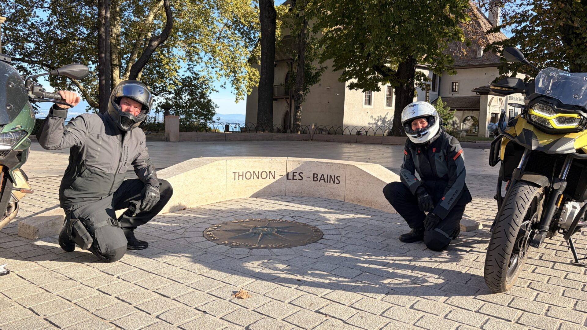 Dominik und Paulina von Motos & Wonders mit ihren Motorrädern beim Kilometer null der Route des Grandes Alpes in Thonon-les-Bains
