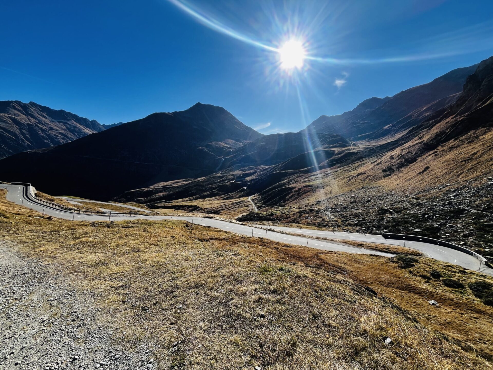 Kurvenreiche Oberalppassstrasse auf der Bündner Seite mit herbstlichen Alpwiesen