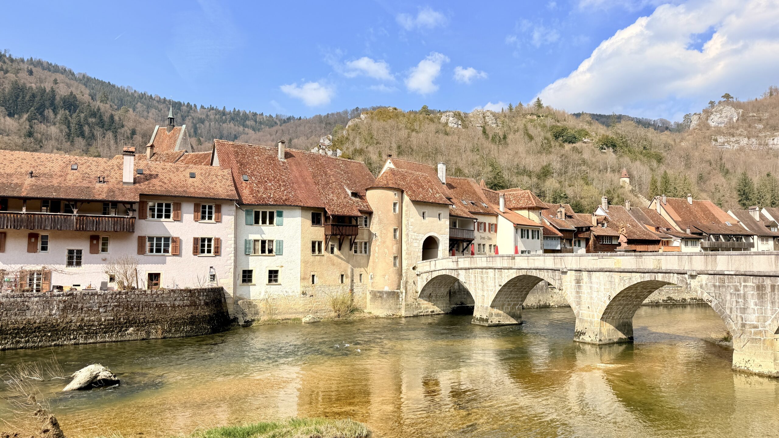 Steinbrücke über den Doubs und Altstadthäuser von Saint-Ursanne